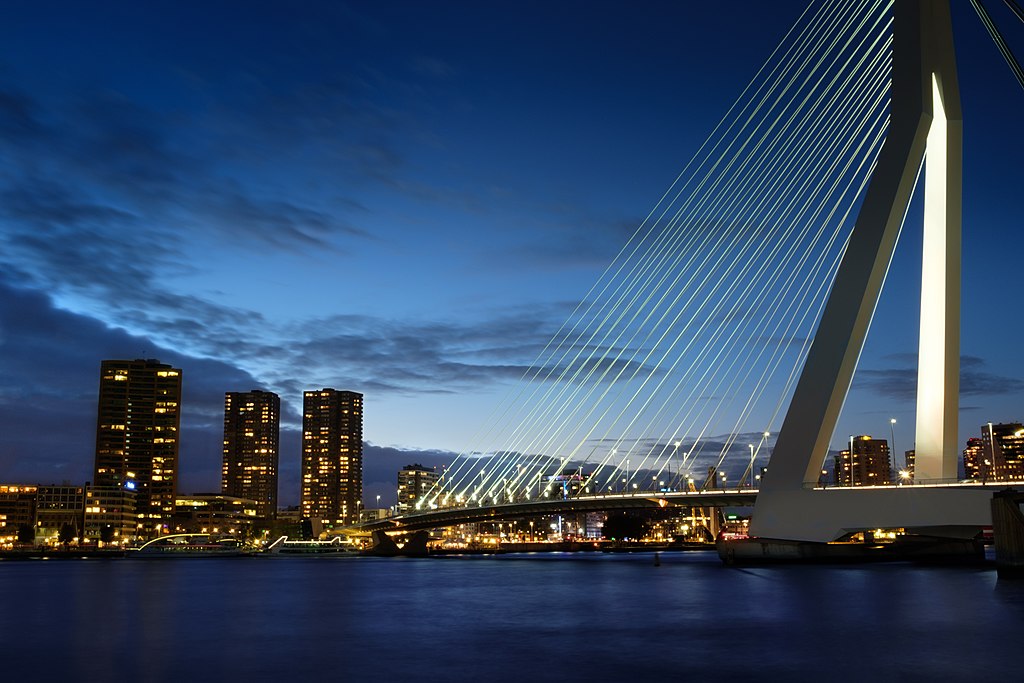 Photo of Rotterdam's skyline at dusk with Erasmusbrug in the foreground.