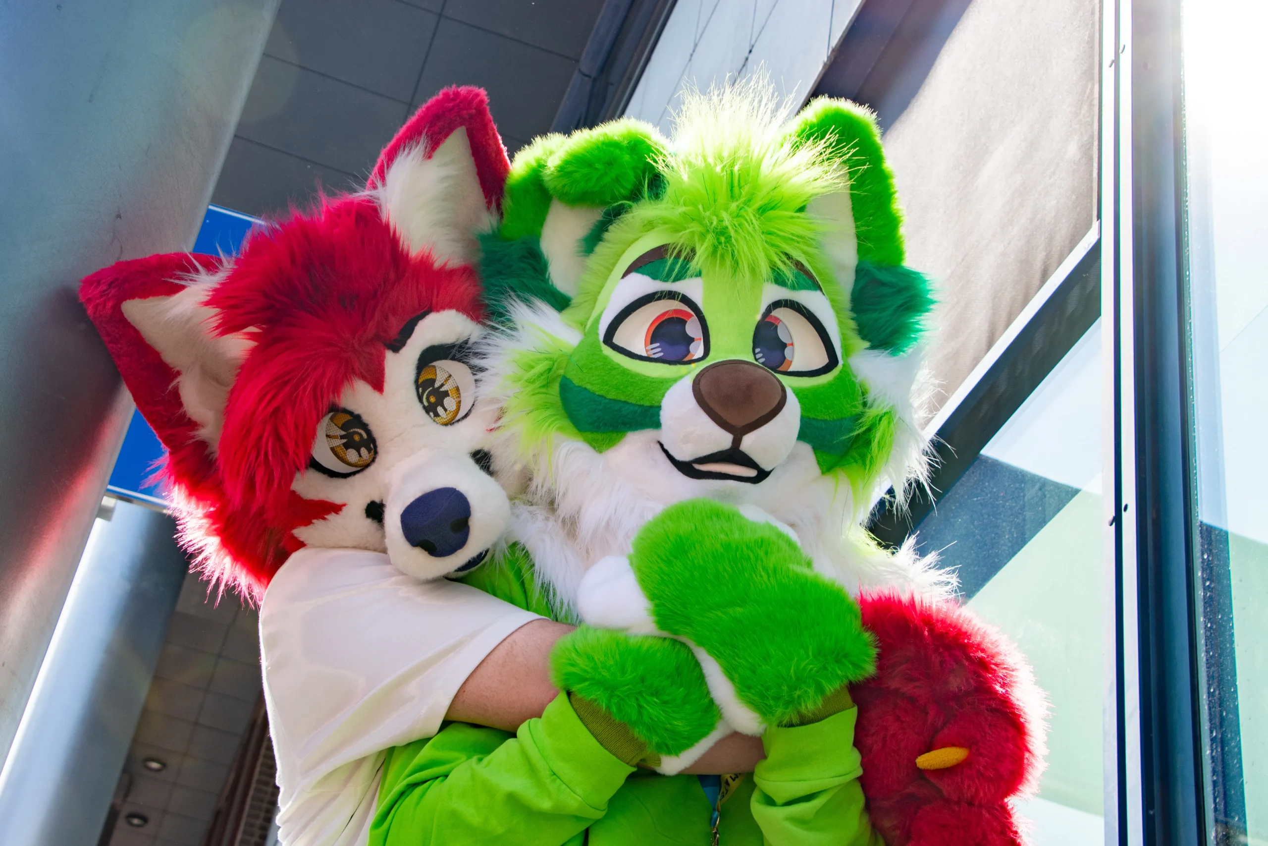 Two colourful fursuiters hugging