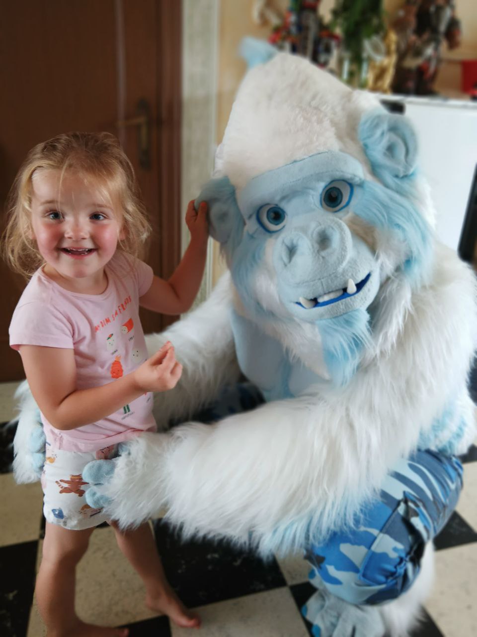 Photo of an ape fursuiter with an excited child